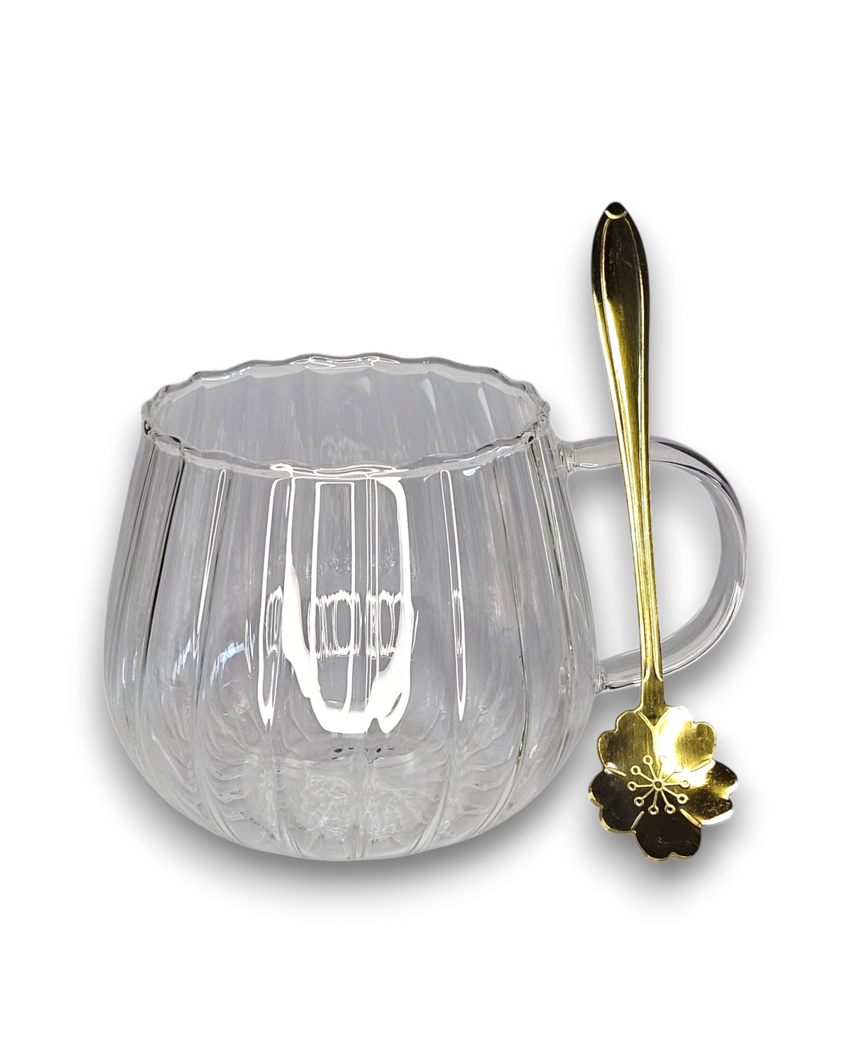 Glastasse mit Bambusuntersetzer und goldenem Löffel
