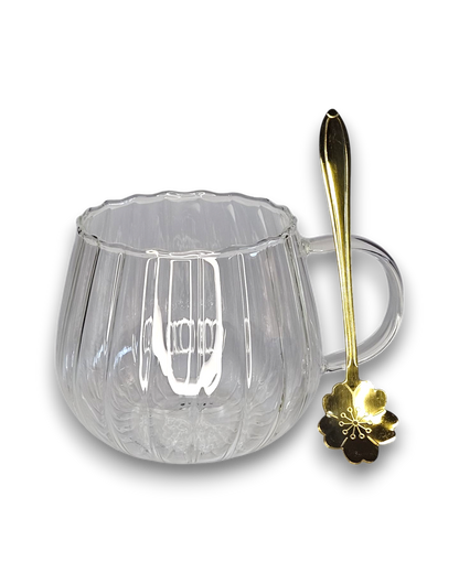 Glastasse mit Bambusuntersetzer und goldenem Löffel